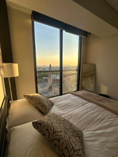 a bedroom with a bed with a large window at Apartment with city views central area in Guadalajara
