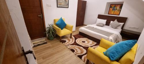 a bedroom with a bed and two yellow chairs at Tailors Cottage in Hatton