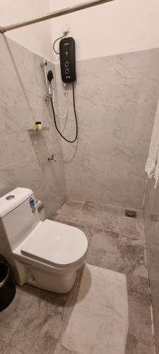 a bathroom with a toilet and a phone on the wall at Tailors Cottage in Hatton