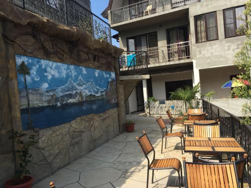 un patio con mesas y sillas junto a un edificio en Guest House Sterh, en Loo