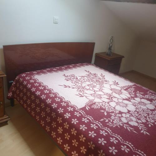 - une chambre dotée d'un lit avec une couverture rouge et blanche dans l'établissement Appartement en campagne, à Taurignan-Castet