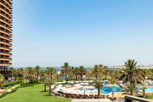an aerial view of a resort with a pool and palm trees at Le Royal Meridien Beach Resort & Spa Dubai in Dubai