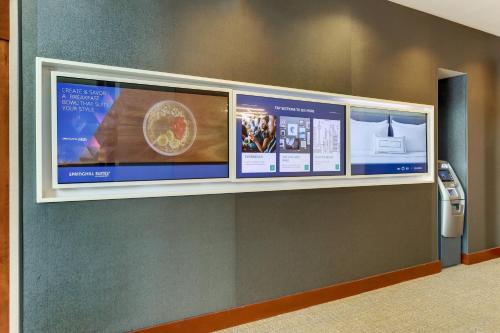 a wall with three monitors on a wall at SpringHill Suites by Marriott Birmingham Downtown at UAB in Birmingham