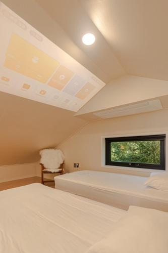 a bedroom with two beds and a window at 32평자쿠지독채 지금애월 in Jeju