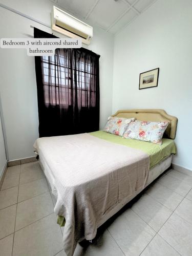 a bedroom with a bed in a room with a window at 5 Bedroom House Near Sunway Lagoon in Petaling Jaya