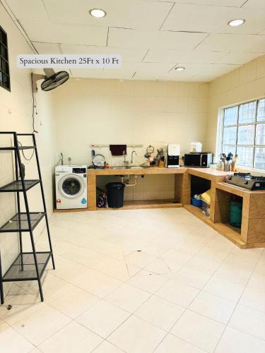 a kitchen with a counter and a washing machine at 5 Bedroom House Near Sunway Lagoon in Petaling Jaya
