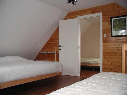 1 dormitorio con 2 camas y puerta a un armario en De Bosbeekpoort en Opglabbeek