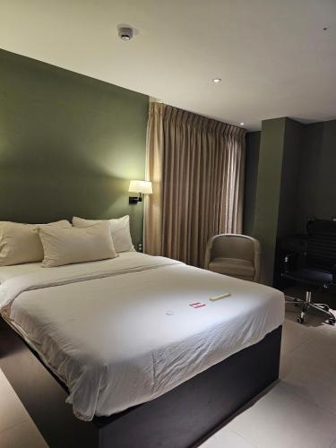 a hotel room with a large bed and a chair at Valentino's Hotel in Angeles