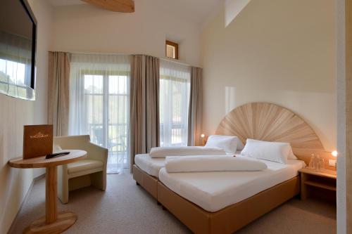 Cette chambre comprend 2 lits et une fenêtre. dans l'établissement Kraftquelle Schlossblick, à Angerberg