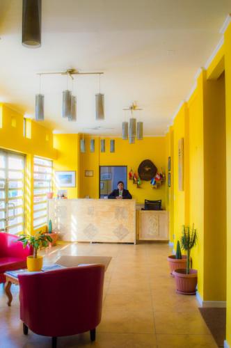 a room with yellow walls and a man behind a counter at Ayelen Express in Calama