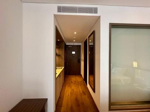 a hallway leading to a kitchen with white walls at Resort Mandala's By Cozy Apec in Mui Ne