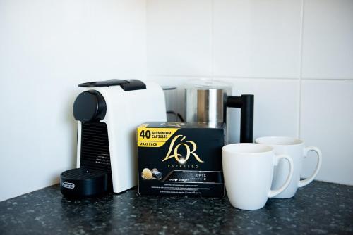 a counter with two cups and a box of coffee at Bay Getaway - Beach, Nature walks and a Two Storey House in Orobilbah Island