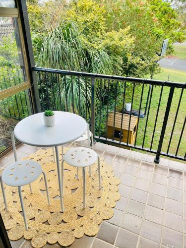a white table and two stools on a balcony at Bay Getaway - Beach, Nature walks and a Two Storey House in Orobilbah Island