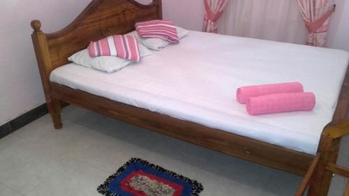 a bed with pink and white pillows on it at veranda guest home in Mirissa
