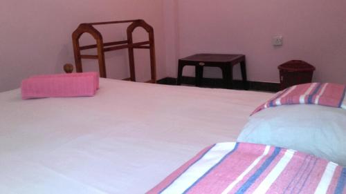a bedroom with a large white bed and a chair at veranda guest home in Mirissa