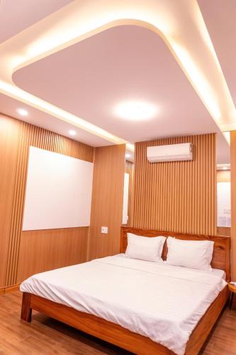 Un dormitorio con una gran cama blanca en una habitación. en Cherry homestay bmt, en Buôn Ðũng