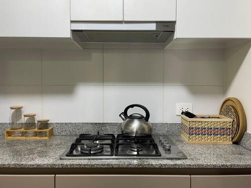 a tea kettle sitting on top of a stove in a kitchen at Amplio y Calido Departamento en Ubicación Centrica in Lima