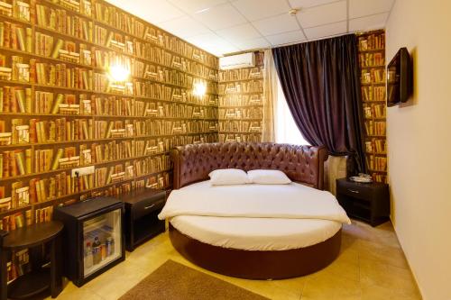 1 dormitorio con 1 cama y una pared de libros en Marton San Remo Krasnodar, en Krasnodar