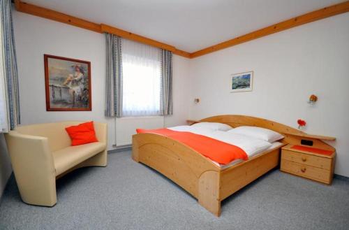 a bedroom with a wooden bed and a chair at Appartements Familie Grundner in Leogang
