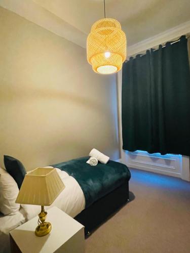 a bedroom with a bed and a lamp and a window at Elms West Court in Sunderland