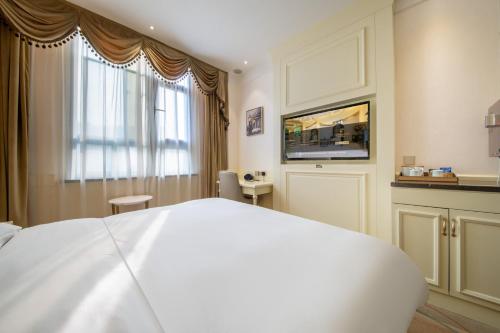 a bedroom with a white bed and a window at Center Hotel Xi'an Bell Tower in Xi'an