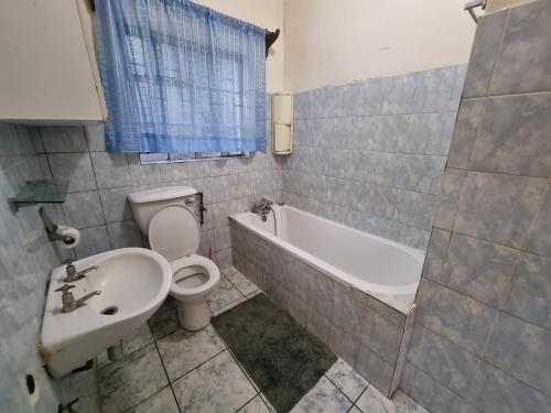 Un baño con inodoro, bañera y lavabo. en The Leafy Haven- A feel of home!, en Harare