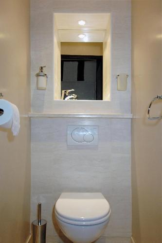 une salle de bain avec des toilettes blanches et un miroir dans l'établissement HolidaysInParis-Bourg Tibourg II, à Paris