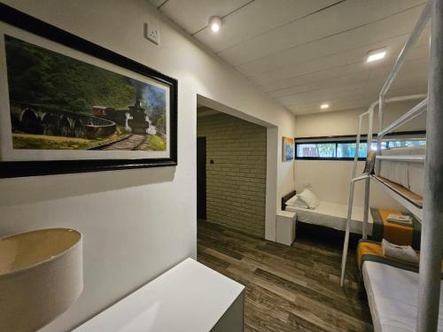 a room with a bunk bed and a bedroom with a train picture at BBQ HUB Ella in Ella