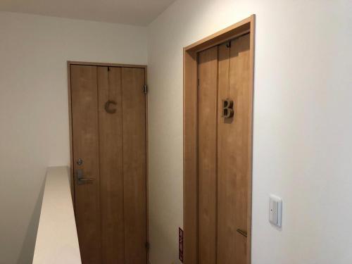 an empty room with a wooden door and stairs at Casa上熊本 1 in Kumamoto