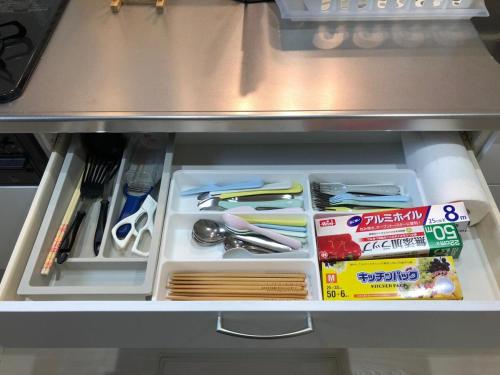 a drawer in a refrigerator filled with utensils at Casa上熊本 1 in Kumamoto