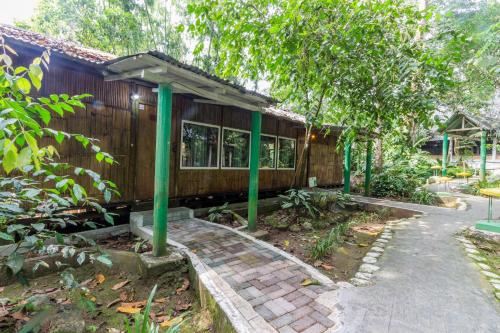 a small house with green poles in front of it at Hosteria El Paraiso de las Orquideas in Archidona