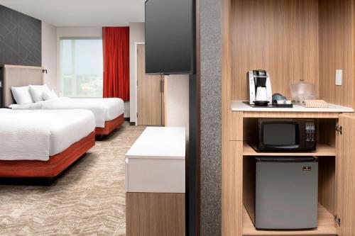 a hotel room with two beds and a tv at SpringHill Suites by Marriott Punta Gorda Harborside in Punta Gorda
