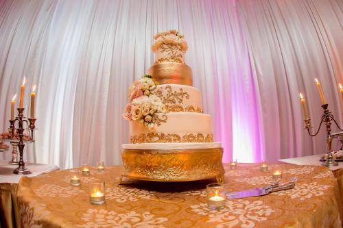 a wedding cake sitting on top of a table with candles at Miami Marriott Dadeland in Miami