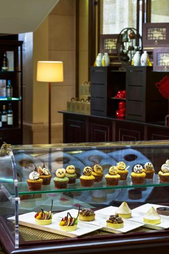 a display case with cupcakes and muffins on display at The St. Regis Beijing in Beijing