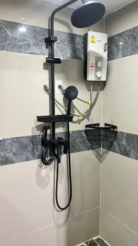 a shower in a bathroom with a blow dryer at Pa Chalermchai Guesthouse in Bang Kapi