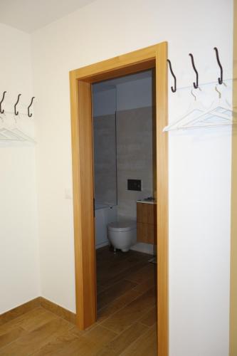 a bathroom with a door leading to a toilet at Chesa Muragls in Pontresina