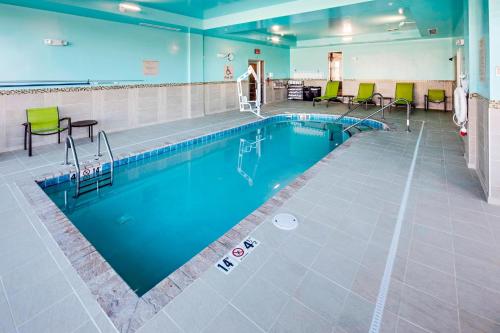 a swimming pool with chairs and tables in a large room at SpringHill Suites by Marriott Dayton Vandalia in Murlin Heights