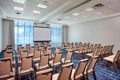 a conference room with chairs and a white screen at Sheraton Suites Philadelphia Airport in Philadelphia