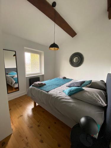 - une chambre avec un lit et un miroir dans l'établissement La Petite Maison, jardin et jacuzzi, proche de Lyon, à Charly