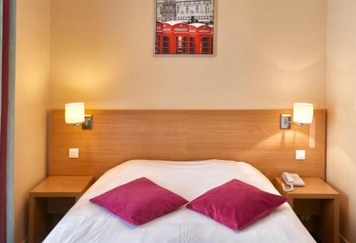 a bedroom with a bed with two red pillows at Hôtel du Nord in Annecy