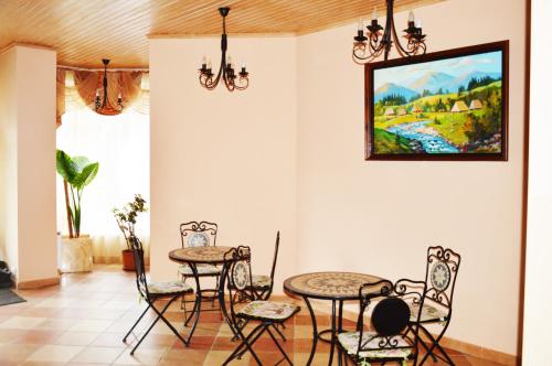 科洛洽瓦的住宿－Agio Hotel，用餐室配有桌椅和墙上的绘画作品
