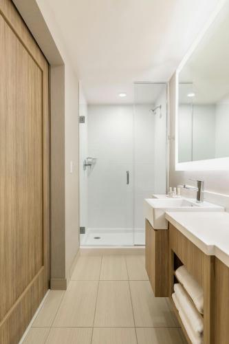 a bathroom with two sinks and a shower at SpringHill Suites St. Paul Downtown in Saint Paul