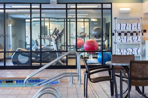 a gym with chairs and a table and mirrors at SpringHill Suites Minneapolis West St. Louis Park in Saint Louis Park