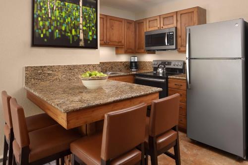 a kitchen with a white refrigerator and a table with chairs at Marriott's Mountain Valley Lodge at Breckenridge in Breckenridge