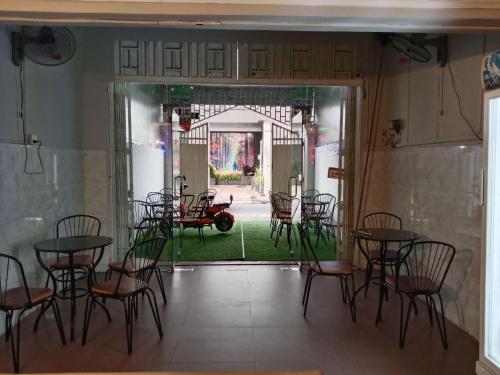una habitación con mesas y sillas y una puerta a un patio en KN HOSTEL & Coffee - Spa, en Phnom Penh