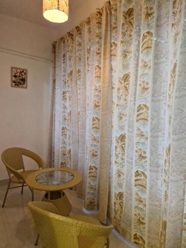 a room with a table and chairs and a curtain at Cozy Cabana - The Perfect Getaway in Benaulim
