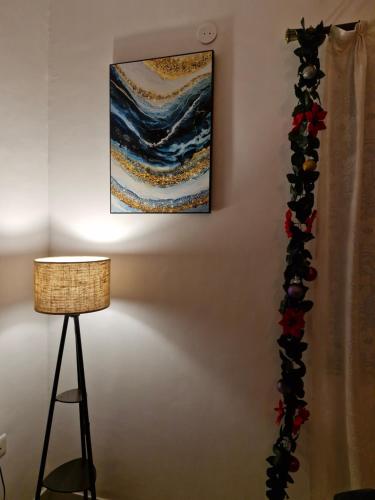 a painting hanging on a wall next to a lamp at Cozy Cabana - The Perfect Getaway in Benaulim