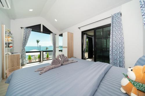 a bedroom with a large bed with a large window at 哦先生的海景别墅 Aoyon Beach in Phuket Town