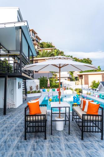 a pool with a table and chairs and an umbrella at 哦先生的海景别墅 Aoyon Beach in Phuket Town