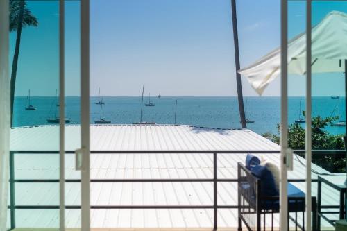 a person sitting in a chair on a balcony looking at the ocean at 哦先生的海景别墅 Aoyon Beach in Phuket Town